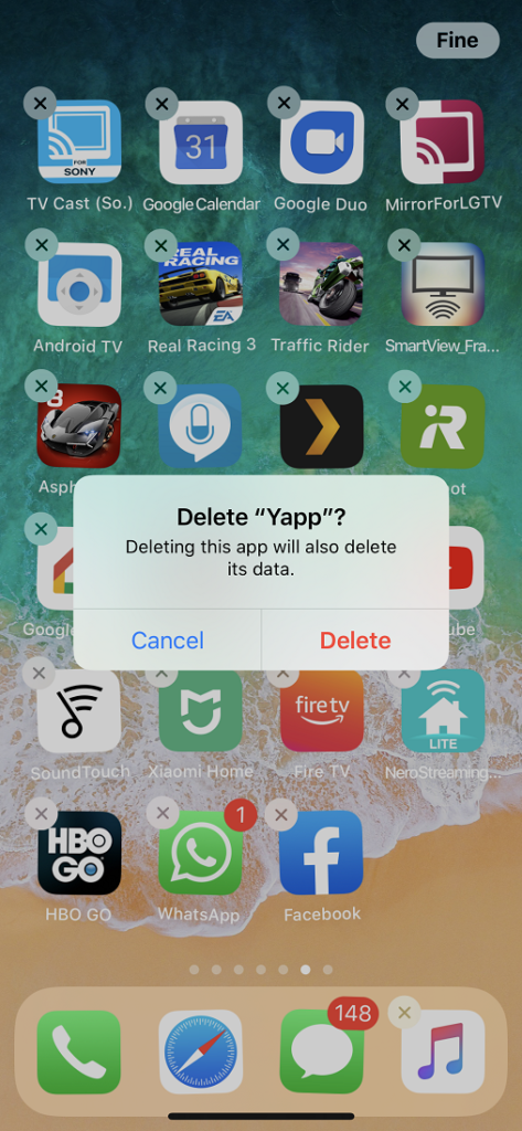 L'immagine mostra lo schermo di un iPhone con le applicazioni installate e una finestra pop-up che chiede se l'applicazione verrà eliminata.