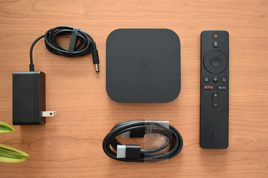 L'immagine mostra ciò che è incluso nella confezione del Mi box S 4k: il box tv, il telecomando, il cavo HDMI e un caricabatterie.