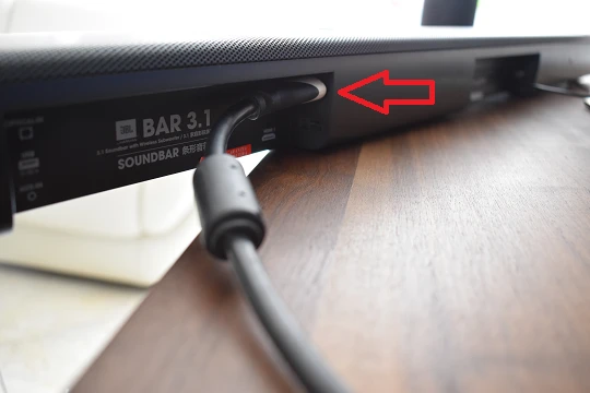 L'immagine mostra il retro di una soundbar con il cavo HDMI collegato alla porta HDMI ARC.
