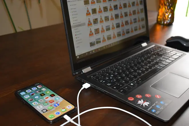 iPhone collegato a un laptop tramite cavo USB
